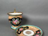 two cups and saucers are sitting on a gray surface