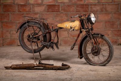 a old motorcycle that is sitting in front of a brick wall
