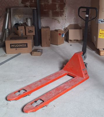 un cariste dans un garage, avec des cartons en arrière-plan