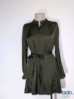 the dress is green and has long sleeves and a belt