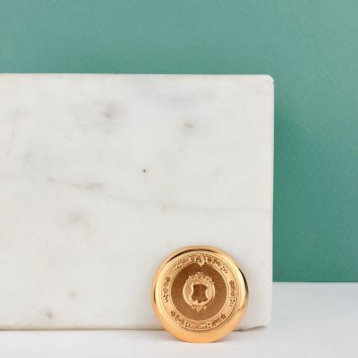une pièce d'or posée sur un bloc de marbre blanc