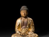 une statue en or représentant une personne assise en position de méditation