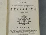 un livre ouvert posé sur une table, à côté d'une nappe bleue