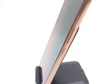 a cell phone that is on a stand on a white surface