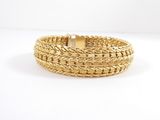 a close up of a gold bracelet on a white background