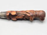 a wooden object with a metal handle on a white surface