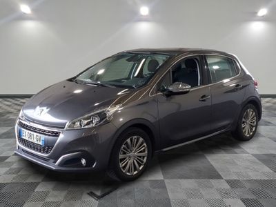 the grey car is parked on a checkered floor in a garage