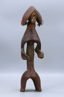 a wooden statue of a woman with a hat on her head