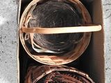 une boîte remplie de paniers contenant de la laine et une brochette en bois