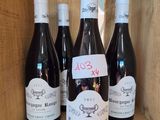 six bottles of wine in a wooden box with labels on them