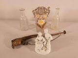 a small statue of a man holding a cane next to a glass vase
