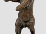 statue d'un ours debout sur ses pattes arrière, posée sur un socle en bois