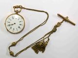 une montre de poche en or et une croix posées sur une table blanche