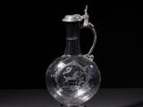 an old glass jug with a handle on a black background
