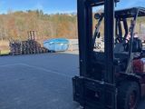 a man driving a forklift in a parking lot