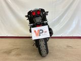 a motorcycle that is parked in front of a white wall