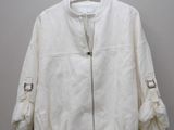 La veste blanche est suspendue à un cintre accroché au mur.