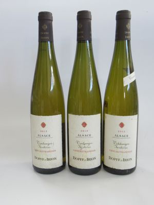 three bottles of white wine are lined up on a white surface