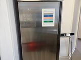 a stainless steel refrigerator in a kitchen with a sign on the door