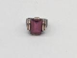 un gros plan d'une bague sertie d'une pierre rose