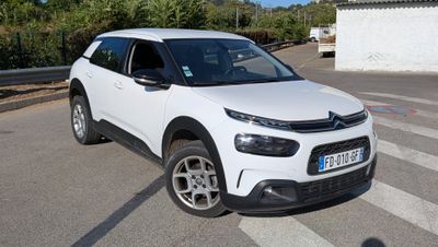 la voiture blanche est garée sur le côté de la route