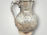 an image of a silver pitcher with a horse and rider on it