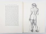 an open book with a drawing of a nude woman on it