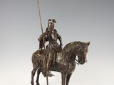 bronze statue of a man on a horse with a spear