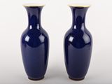 une paire de vases bleus aux bords dorés sur fond blanc
