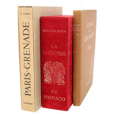 trois livres sont empilés sur une surface blanche