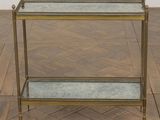gold metal and glass serving cart with two shelves on top of it