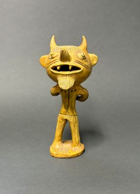 une image représentant une figurine jaune représentant un démon à cornes