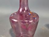 a pink glass vase sitting on a table