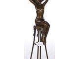 une statue en bronze représentant une femme assise sur un tabouret
