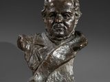 a bronze bust of a man holding a knife in his right hand
