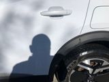 a shadow of a man standing next to a white car