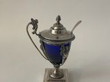 an antique silver plated cup with a blue glass in the center
