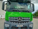 un grand camion vert garé sur un parking