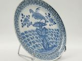 blue and white plate with a bird on top of a wave
