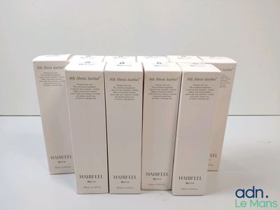 quatre boîtes de parfum vides posées sur une surface blanche