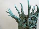 une sculpture représentant une main tenant une horloge ornée de cornes