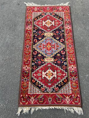un tapis rouge et bleu sur un sol gris