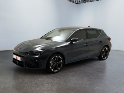 La voiture grise est garée dans une grande pièce aux murs blancs