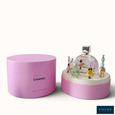 chanel perfume bottle in a pink box on a white surface