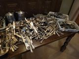 a lot of silverware on a table in a room