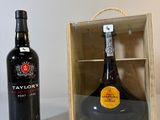 une bouteille de vin dans un coffret en bois à côté d'une bouteille de vin