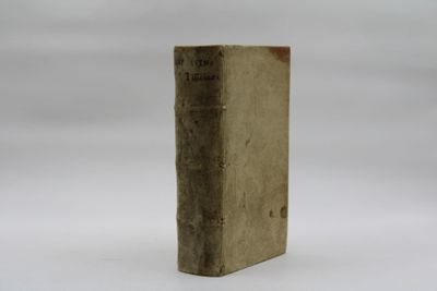 an old book sitting on top of a table on a white surface