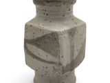 a gray vase that is sitting on a white surface