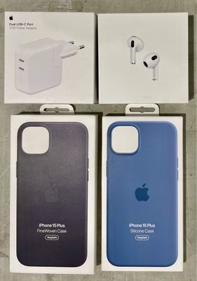 trois boîtes contenant des coques pour iPhone et des écouteurs, posées sur une table