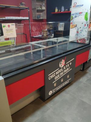 une vitrine en verre sur laquelle est accrochée une affiche, dans un magasin